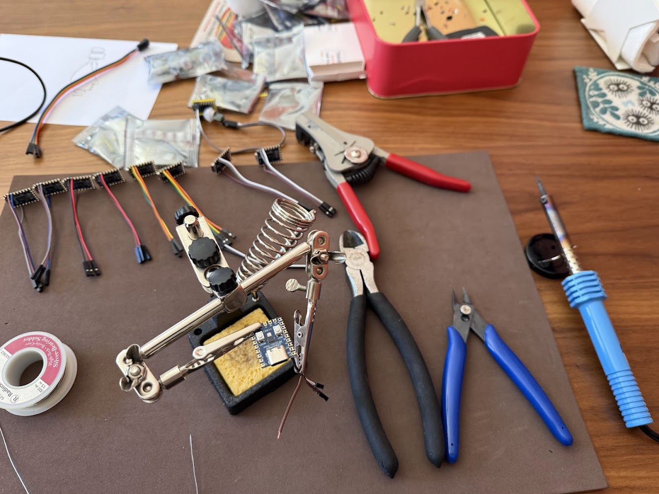 Hand-soldering MOTIONSENSR units — RP2040-Zero and AM312 wired on a workbench