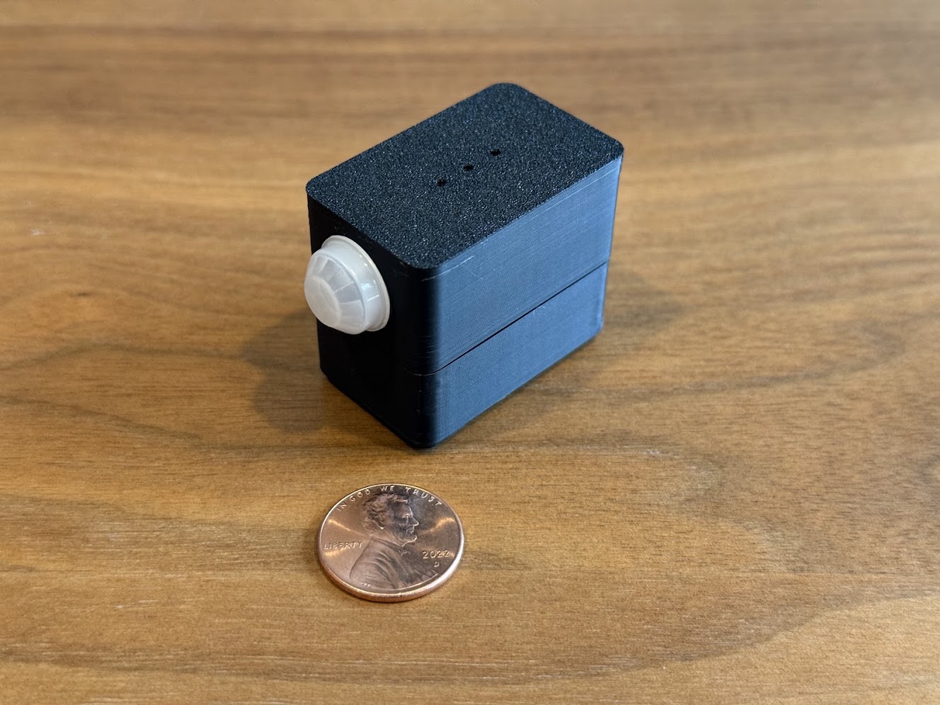 MOTIONSENSR USB motion sensor — front view showing PIR dome, with penny for scale